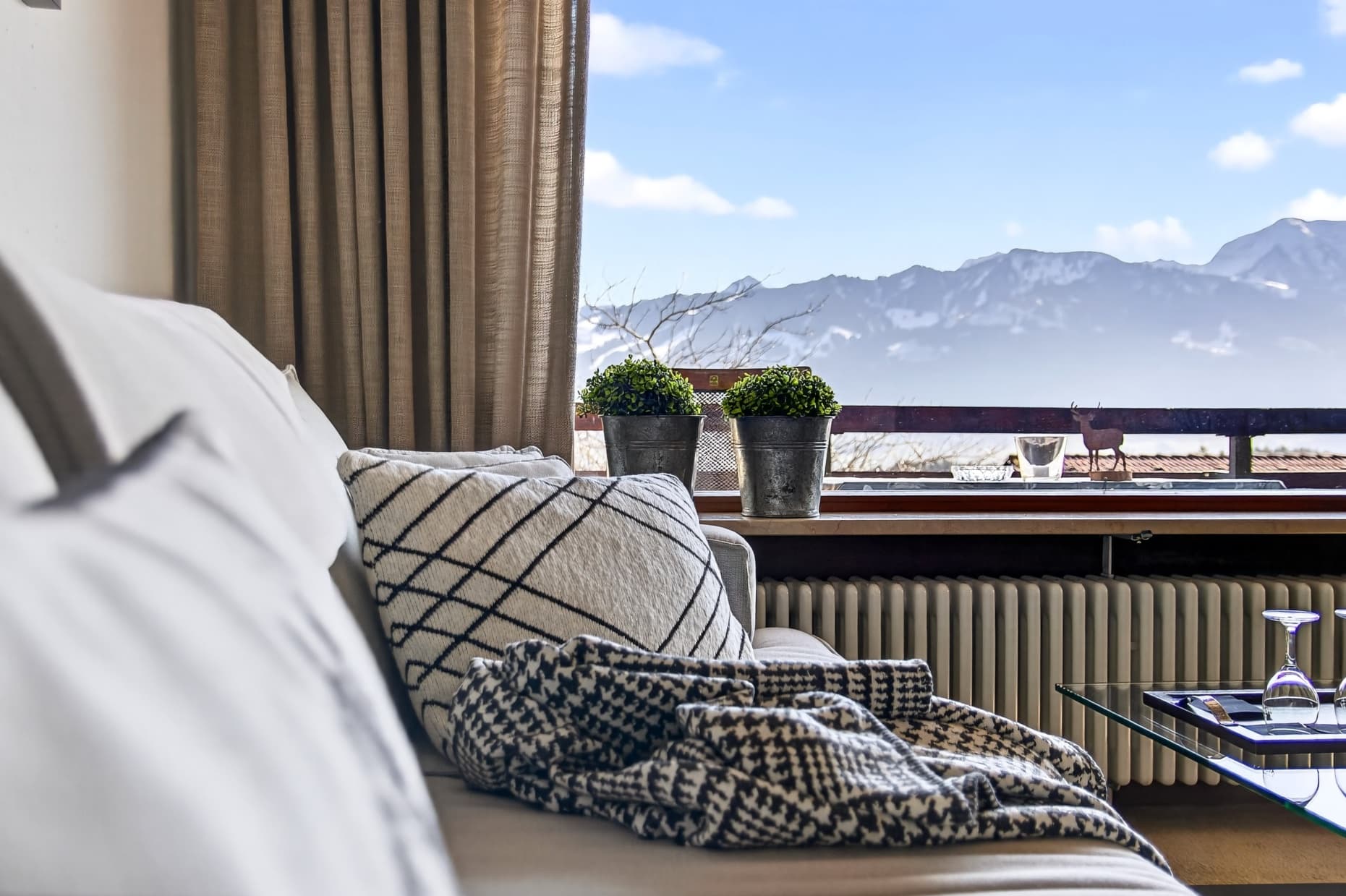 Gemütlicher Wohnbereich der Ferienwohnung Allgäu – Couch mit Wolldecke